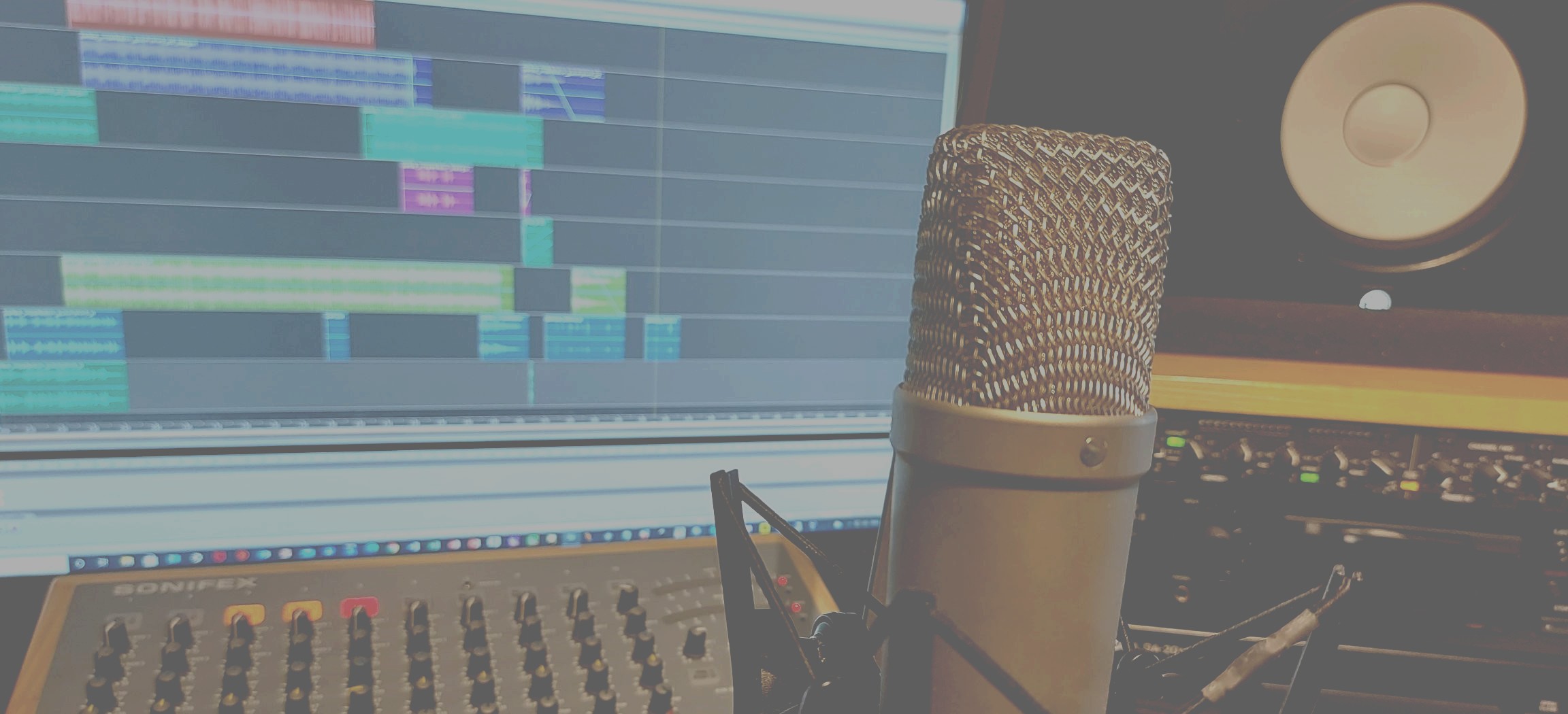 A photo of the Infosound audio studio, showing a computer screen, mixer, microphone and other sound equipment